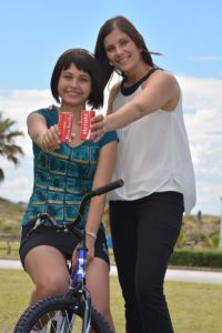 Powerade representative Cheryl Price and Reach for a Dream beneficiary Rochelle Momberg (on bike) share a Coke ahead of the Powerade-sponsored children's events, which form part of The Herald VW Cycle Tour on February 1 and 2. All proceeds from these events benefit Reach for a Dream. Photo: Coetzee Gouws/Full Stop Communications