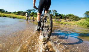 Riders making their way through a section of water on the iMfolozi MTB Challenge route.