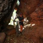 A rider pushes his bike through a cave during the Trailseeker Diamond Rush event.