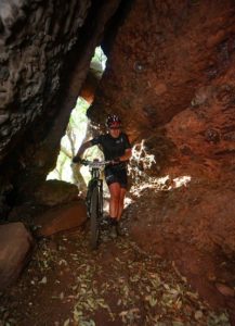 A rider pushes his bike through a cave during the Trailseeker Diamond Rush event.