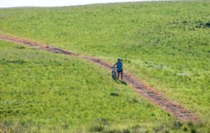 A picture of a rider waving at the photographer during stage one of the Drak Descent.