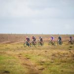 Wide pan shot of riders taking on a bend in an open field during the PE Plett. Photo: Deidre Cloete