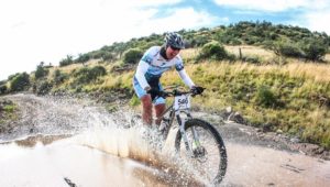 A rider smiles as he passes through a section of water on stage one of Trek 2 Teebus