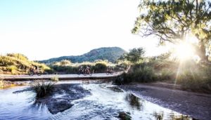 Riders passing a beautiful section of water on the final Trek 2 Teebus stage