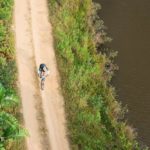 Aerial shot of a solo rider taking on a track alongside a river during the sani2c Race. Photo: Anthony Grote