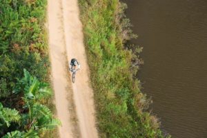 Aerial shot of a solo rider taking on a track alongside a river during the sani2c Race. Photo: Anthony Grote