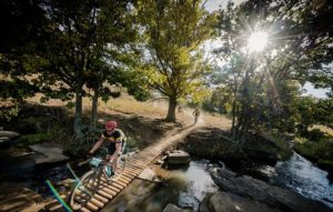 A mountain biker crosses a wooden bridge on day one of sani2c Adventure