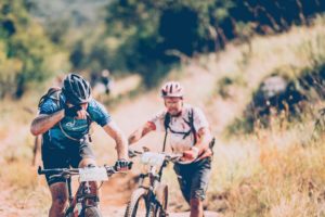 Tired riders push their bikes along the route on day two of sani2c Adventure