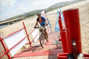 Riding over scaffolding on the final day of the sani2c Trail