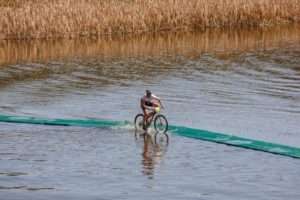 A rider crosses a bridge over water on day one of sani2c Trail.