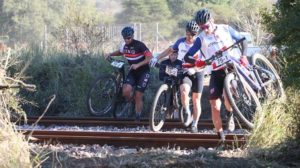 Leading riders carrying their bikes across a train track during stage three of the Waterberg MTB Encounter. Photo: Gerrie Kriel / Twin Productions SA