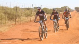 Riders taking on a dusty and flat gravel road during stage three of the Waterberg MTB Encounter. Photo: Gerrie Kriel / Twin Productions SA