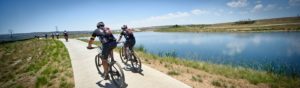 Mountain bikers pass a stunning dam during the 947 MTB Challenge
