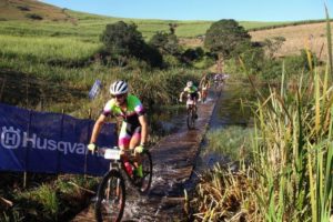Mountain bikers cross a bridge during the Husqvarna Classic
